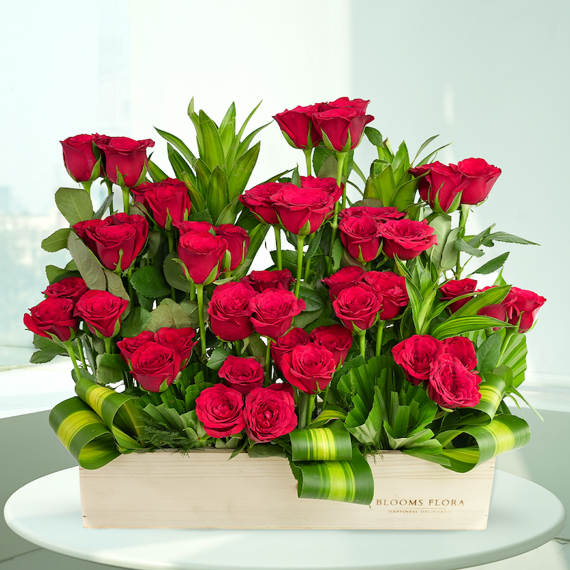 wooden box of 48 red roses